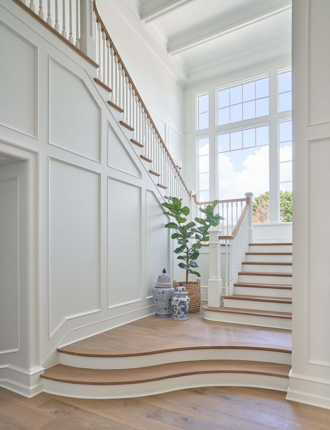 Elegant Staircase with White Wood Ceiling and Wall Paneling