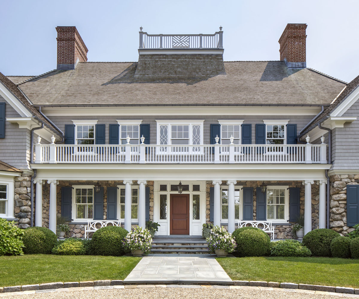 Front Facade with Rustic Fieldstone Wall Behind a Porch Framed by Scamozzi Ionic Columns