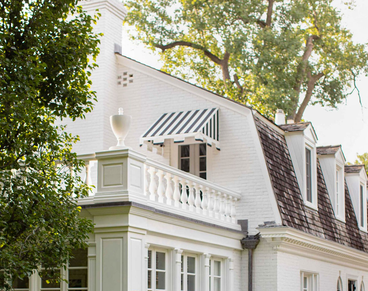 Elegant Home with Striped Awning and Classic Architectural Details