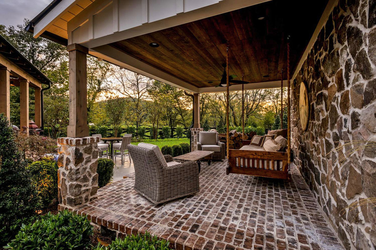 Rustic Covered Porch With Daybed Swing