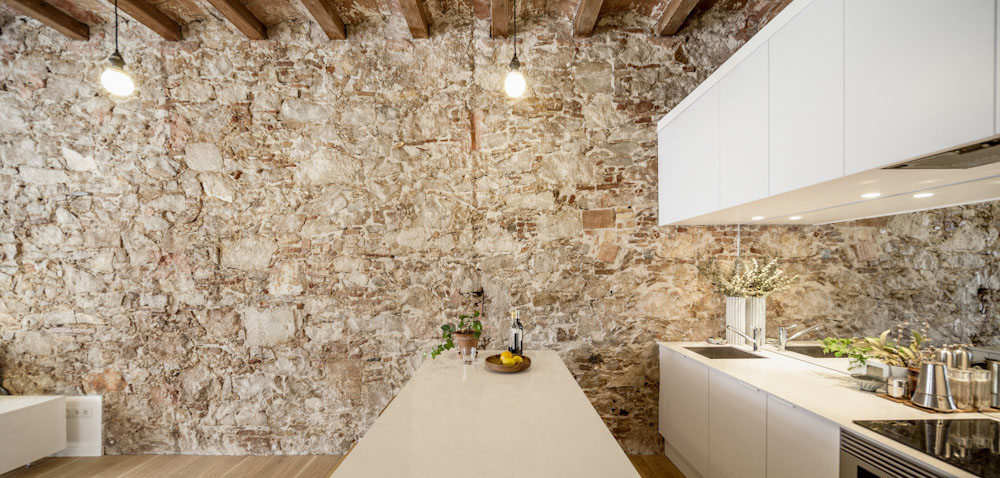 Minimalist White Kitchen with Rustic Stone Wall