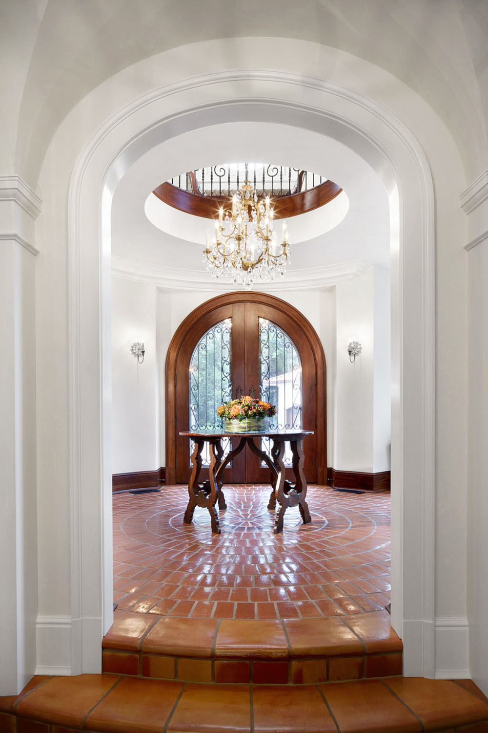 Arched Wood Front Door with Tuscan Terra-Cotta Tile Foyer