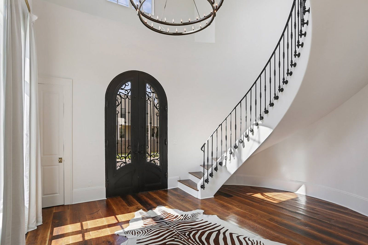 Curved-Open Staircase with Iron Railings in Foyer