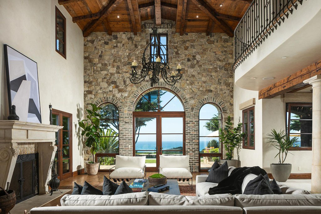 Living Room with Large Arched Window and Rustic Stone Wall