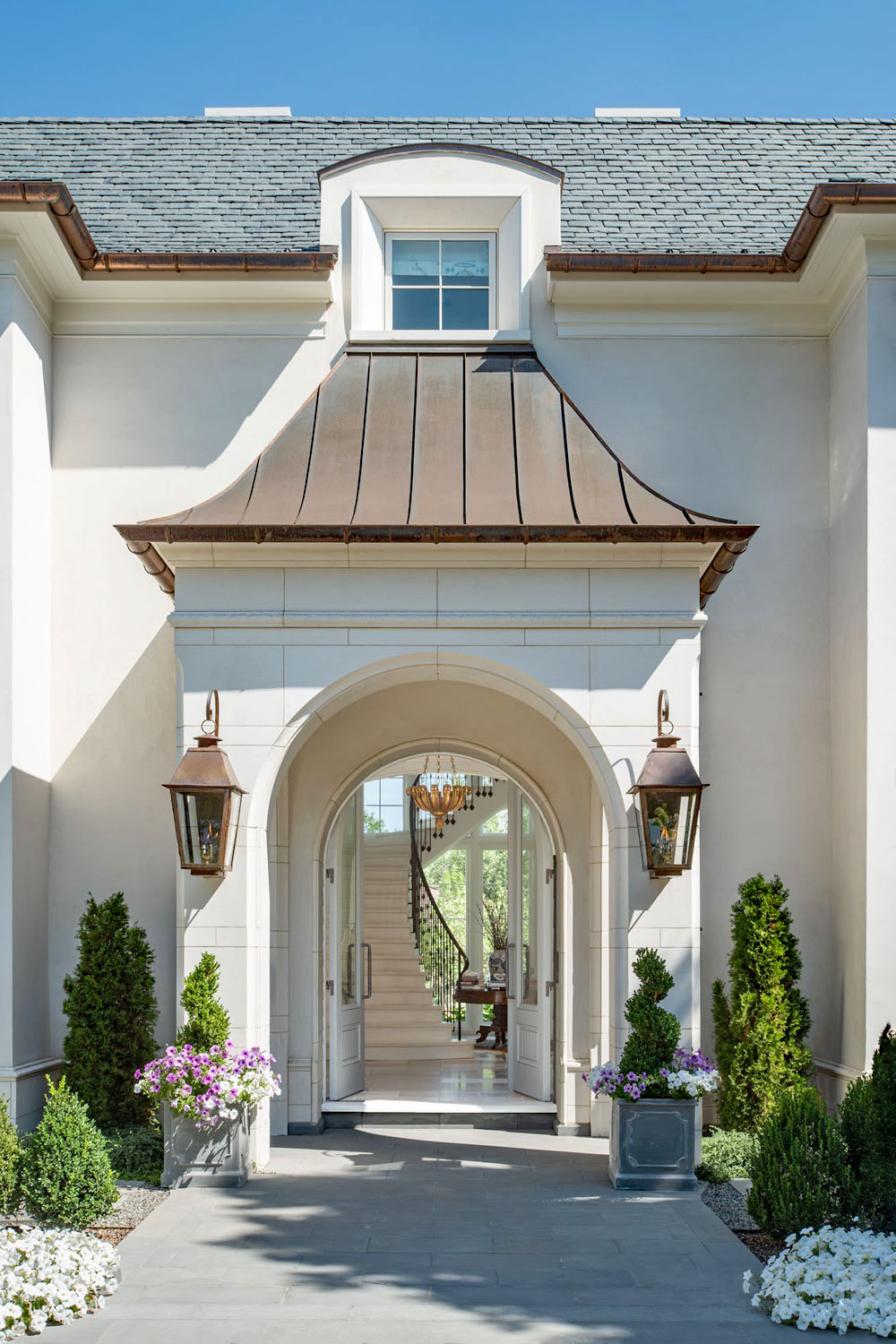 Gas lanterns flank the arched front entry with copper roof