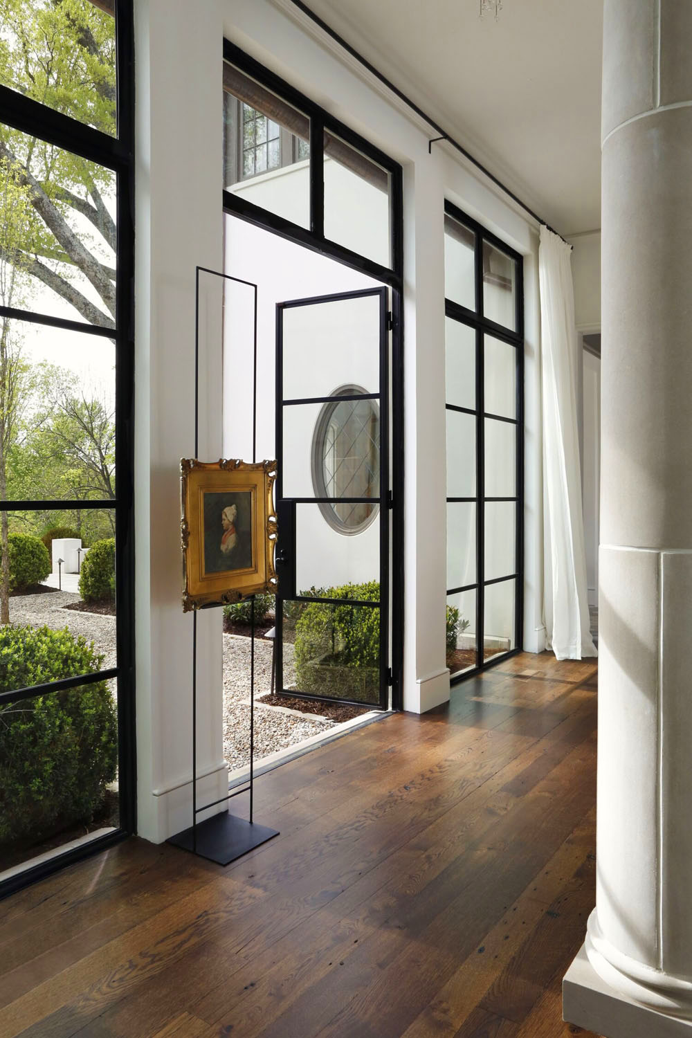 Hallway with Roman Columns and Black Steel French Doors