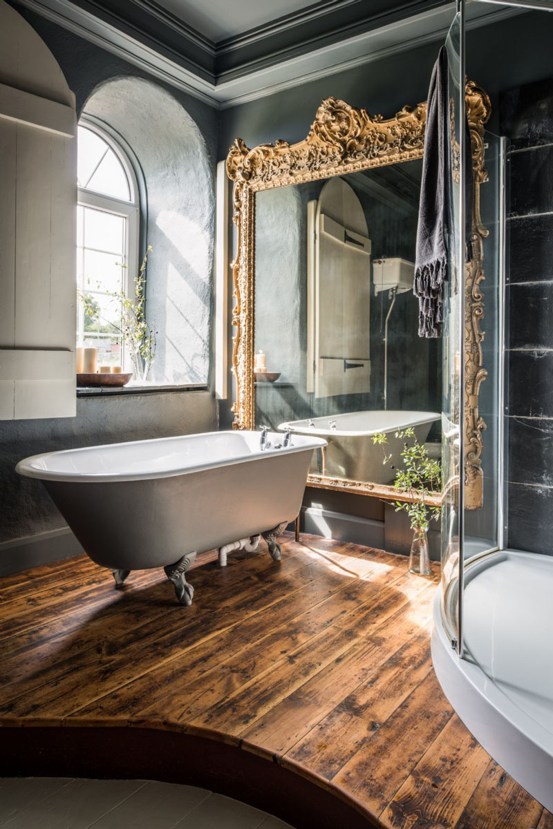 Bathroom with Mirrored Wall and Clawfoot Bathtub