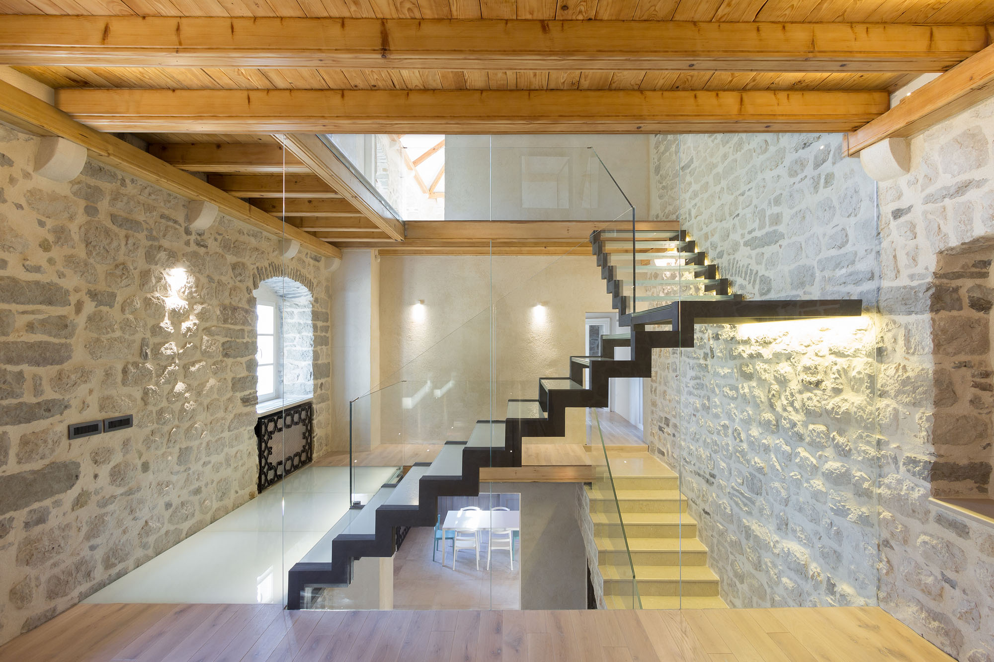 Rustic Stone Walls and Modern Glass Staircase