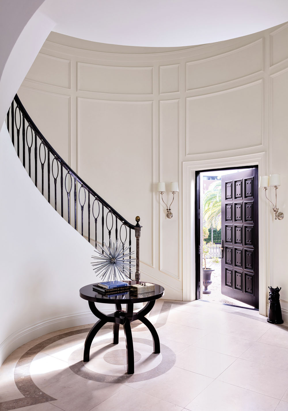 Dramatic Curving Staircase with White Wainscoting